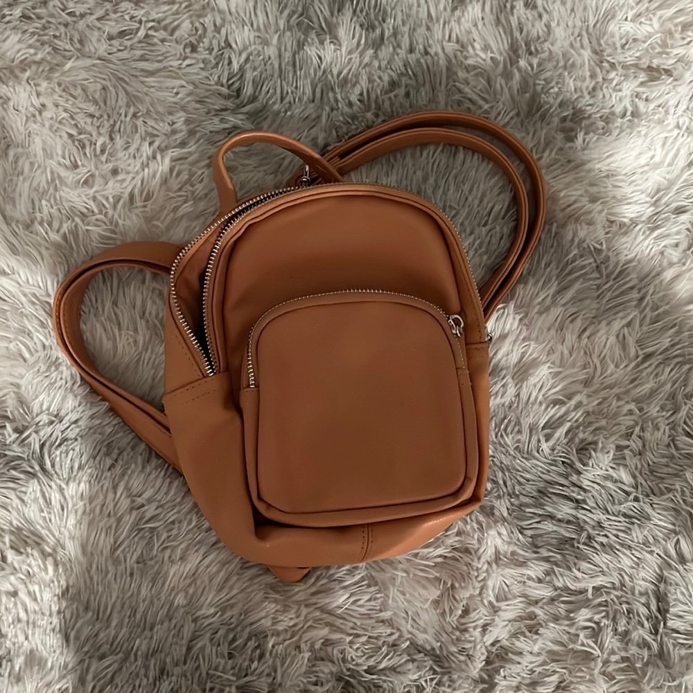 Tan-ish mini backpack can fit chapstick, phone, wallet and adjustable straps